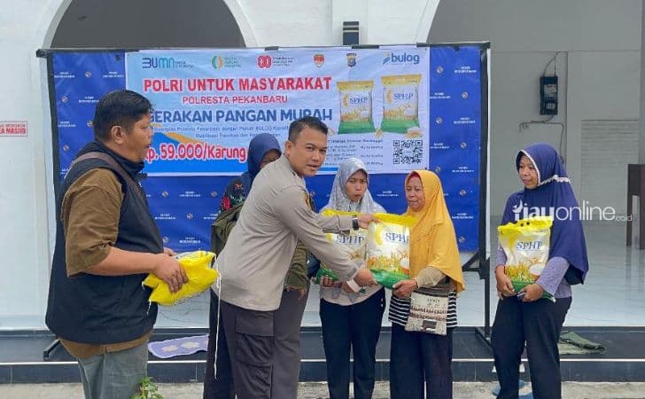 Kapolsek-Rumbai-AKP-Said-Khairul-Iman-menyerahkan-pangan-murah-kepada-warga.jpg
