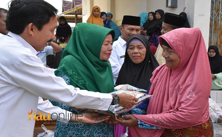 NURAINI-AZIS-menyerahkan-beras-kepada-masyarakat.jpg