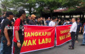 Massa-Bentangkan-Spanduk-Tangkap-Wak-Labu-Saat-SF-Hariyanto-Bersaksi.jpg